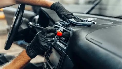 Detailing a car's dashboard and air vents with a brush