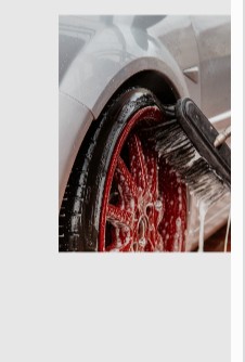 Scrubbing a wheel and rim with a brush and soap